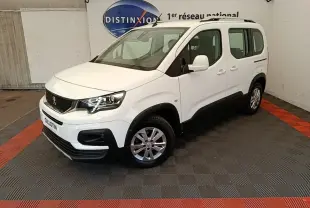 Peugeot Rifter blanc en 3/4 avant droit, avec jantes alliage et protections noires sur bas de caisse.