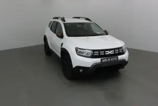 Dacia Duster 4x4 blanc vu en 3/4 avant droit avec rétroviseurs bronze et jantes noires.