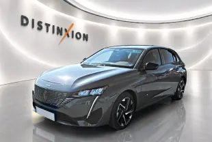 Peugeot 308 gris 3/4 avant droit dans un showroom lumineux avec jantes alliage et signature lumineuse LED.