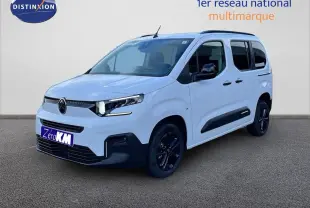 Vue 3/4 avant droite du Citroën Berlingo Multispace blanc glacier avec jantes noires et protections latérales noires.