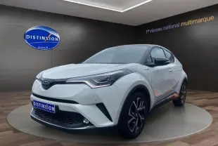 Toyota C-HR Hybride blanc toit noir en 3/4 avant droit, avec jantes noires et détails modernes visibles