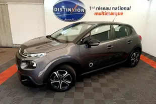 Citroën C3 gris foncé vue 3/4 avant droit, avec protections latérales noires et jantes stylisées en concession.