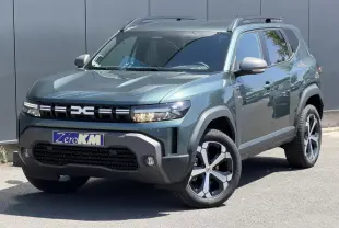 Vue 3/4 avant d'un Dacia Duster Hybrid-G 150 4x4 vert cèdre avec jantes alliage et barres de toit noires.