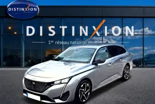 Peugeot 308 SW gris vue 3/4 avant droit, avec jantes alliage et calandre noire distinctive.