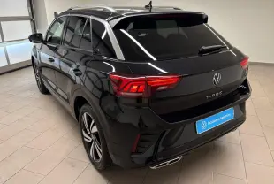 Vue de profil côté gauche du Volkswagen T-Roc 1.5 TSI 150 DSG7 R-Line Edition noir intense dans un intérieur neutre.