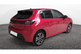 Vue 3/4 arrière droite d'une Peugeot 208 2024 rouge Elixir avec toit noir et jantes alliage distinctives.