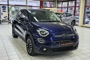 Vue 3/4 avant d'une FIAT 500X bleu nuit 2024 en hybride essence, avec calandre et phares ronds distinctifs en showroom.