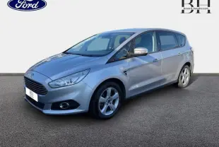 Ford S-MAX gris lunaire en vue 3/4 avant droit, avec calandre chromée et jantes alliage cinq branches.
