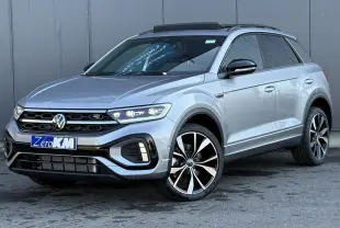Vue 3/4 avant droit d'un Volkswagen T-Roc gris pyrite avec jantes alliage 19 pouces et toit ouvrant noir.
