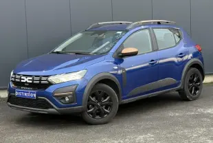 Dacia Sandero Stepway Eco-G 100 Extrême bleu Iron en 3/4 avant droit avec barres de toit et jantes noires.