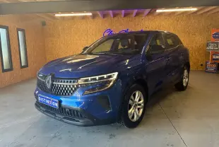 Renault Austral bleu en 3/4 avant droit dans un showroom, avec calandre distinctive et phares LED allumés.