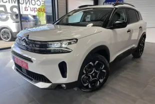 Vue 3/4 avant droite d'un Citroën C5 Aircross blanc nacré avec calandre noire brillante et jantes alliage bi-ton.
