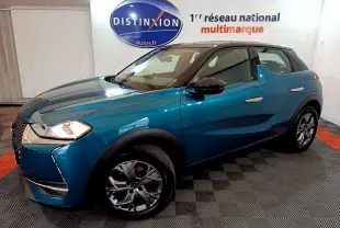 Vue 3/4 avant droit d'un DS3 Crossback bleu métallisé avec toit noir et jantes alliage en showroom.
