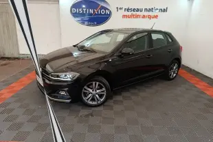 Volkswagen Polo noire 2020 vue 3/4 avant droit en intérieur avec jantes alliage et phares LED allumés.