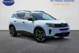 Vue 3/4 avant droit du Citroën C5 Aircross blanc Okénite avec jantes alu et barres de toit noires.