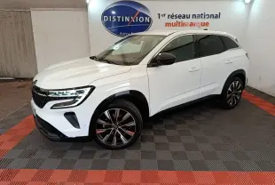 Renault Austral blanc en 3/4 avant droit, avec jantes noires et toit blanc dans un showroom intérieur.