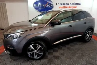 Peugeot 3008 gris foncé en vue 3/4 avant droit, avec jantes alliage et feux LED allumés, stationné en intérieur.