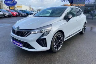 Vue 3/4 avant d'une Renault Clio V gris rafale avec jantes alliage noires et calandre chromée sur parking humide.