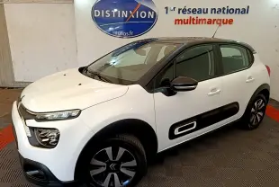 Vue 3/4 avant droite d'une Citroën C3 blanche avec protections latérales noires et jantes bicolores.