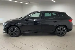 Vue de profil côté gauche d'une Skoda Scala 2025 noire métallisée avec jantes spécifiques Monte-Carlo et double plancher de coffre.