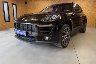 Vue 3/4 avant droite d’un Porsche Macan S noir brillant avec jantes alu 21 pouces et phares bi-xénon en intérieur bois.