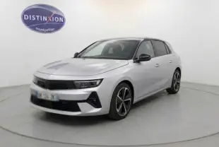 Opel Astra 2024 gris en 3/4 avant droit, avec jantes alliage noires et phares LED modernes visibles.
