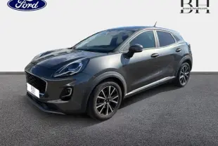 Ford Puma 2024 gris métallisé vu en 3/4 avant droit avec jantes noires et vitres arrière surteintées.
