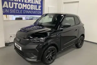 Vue 3/4 avant droite de la Ligier JS50 noire 2026 avec jantes alu noires et feux à LED en intérieur showroom.