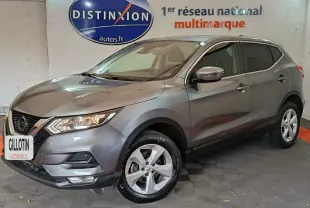 Nissan Qashqai gris clair 2019 en 3/4 avant droit, avec jantes alliage et phares allumés dans un showroom.