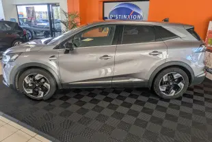 Renault Symbioz gris cassiopée métal vu de profil côté gauche en intérieur avec jantes noires et argentées.