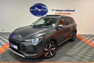 Vue 3/4 avant droite du MG ZS Hybrid+ 197 Luxury gris Candem avec toit panoramique ouvrant en showroom.