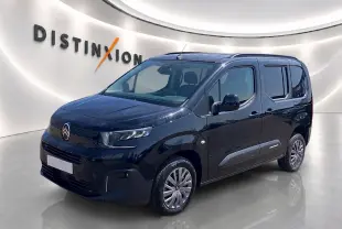 Citroën Berlingo noir vue 3/4 avant droit dans un showroom avec logo Distinxion en arrière-plan.