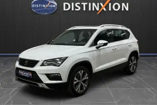 SEAT Ateca blanc en 3/4 avant droit, avec jantes alliage bicolores et toit ouvrant visible en intérieur showroom.