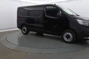Renault Trafic Fourgon noir crépuscule en 3/4 avant droit, avec calandre chromée et phares LED visibles.