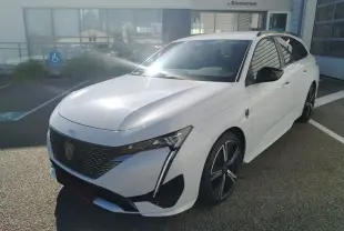 Peugeot 308 SW Hybrid 145 GT blanc Okenite vue 3/4 avant droit, avec calandre noire et jantes alliage noires.