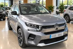 Citroën C3 ë-113 Berline Max gris Artense vue 3/4 avant en intérieur, calandre et phares LED distinctifs.