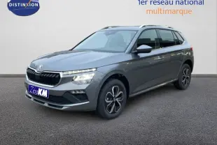 Vue 3/4 avant d'un Skoda Kamiq gris métallisé avec jantes noires et toit argenté sur fond neutre.
