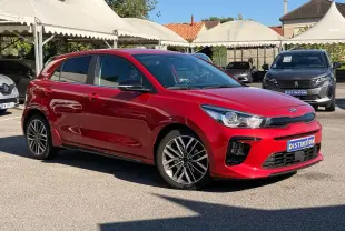 KIA RIO rouge grenadine vue 3/4 avant droit, avec jantes alliage et calandre noire distinctive.