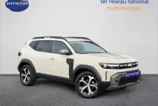 SUV Dacia Duster 2025 couleur Sandstone en vue 3/4 avant, avec jantes alliage et barres de toit noires.