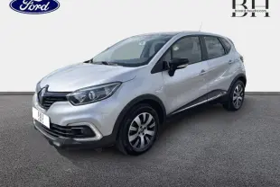 Vue 3/4 avant droit d'un Renault Captur gris platine avec jantes alliage et rétroviseurs noirs sur fond neutre.