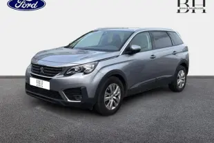 Peugeot 5008 gris Artense vue 3/4 avant droit, SUV avec jantes alu et barres de toit visibles.