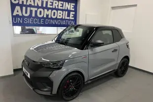 Vue 3/4 avant droite de la Ligier JS50 Sport Ultimate E5+ gris avec toit noir et jantes noires sportives.