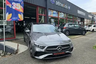 Mercedes A180 gris foncé vue de face 3/4 avant, avec calandre AMG et logo étoile bien visibles.