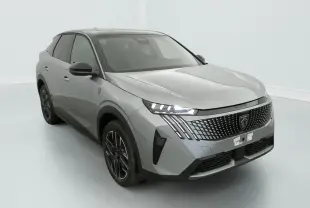 Peugeot 3008 gris clair vue 3/4 avant droit, avec calandre distinctive et feux LED allumés dans un studio blanc.