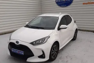 Toyota Yaris 1.5 Hybrid blanc vue 3/4 avant droit, avec jantes alliage et calandre noire distinctive.