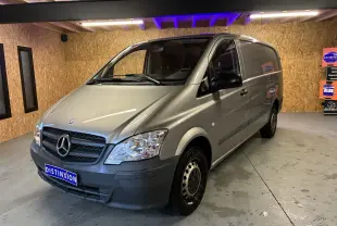 Fourgon Mercedes Vito gris en 3/4 avant droit dans un garage avec éclairage intérieur et plaques Distinxion.