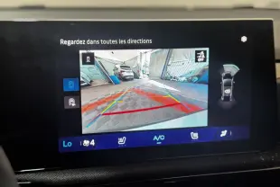 Écran tactile intérieur montrant la caméra de recul et l'aide au stationnement de la Renault Clio gris clair.