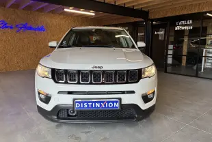 Jeep Compass ivoire vue de face en intérieur, avec calandre noire et plaques Distinxion visibles.