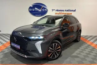 Vue 3/4 avant d’un DS7 gris titane avec signature lumineuse LED distinctive et jantes bi-ton en concession.