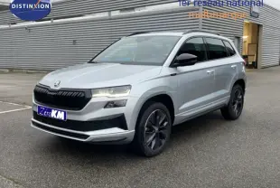 SKODA KAROQ 2025 gris clair en 3/4 avant droit, avec calandre noire et jantes foncées design sportif.